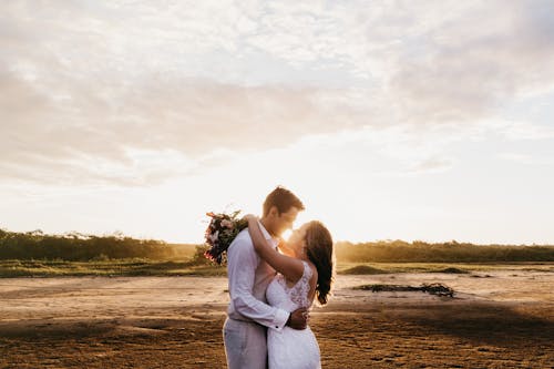 Novios abrazados en la playa al atardecer
