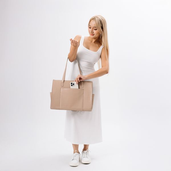 A pale handbag carried against a soft light background — photo by Vui Studio on Pexels