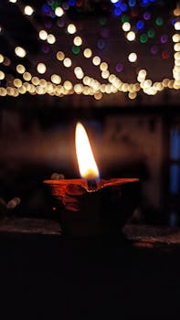 A clay diya glows warmly amidst colorful bokeh lights, capturing the essence of Diwali festivities.
