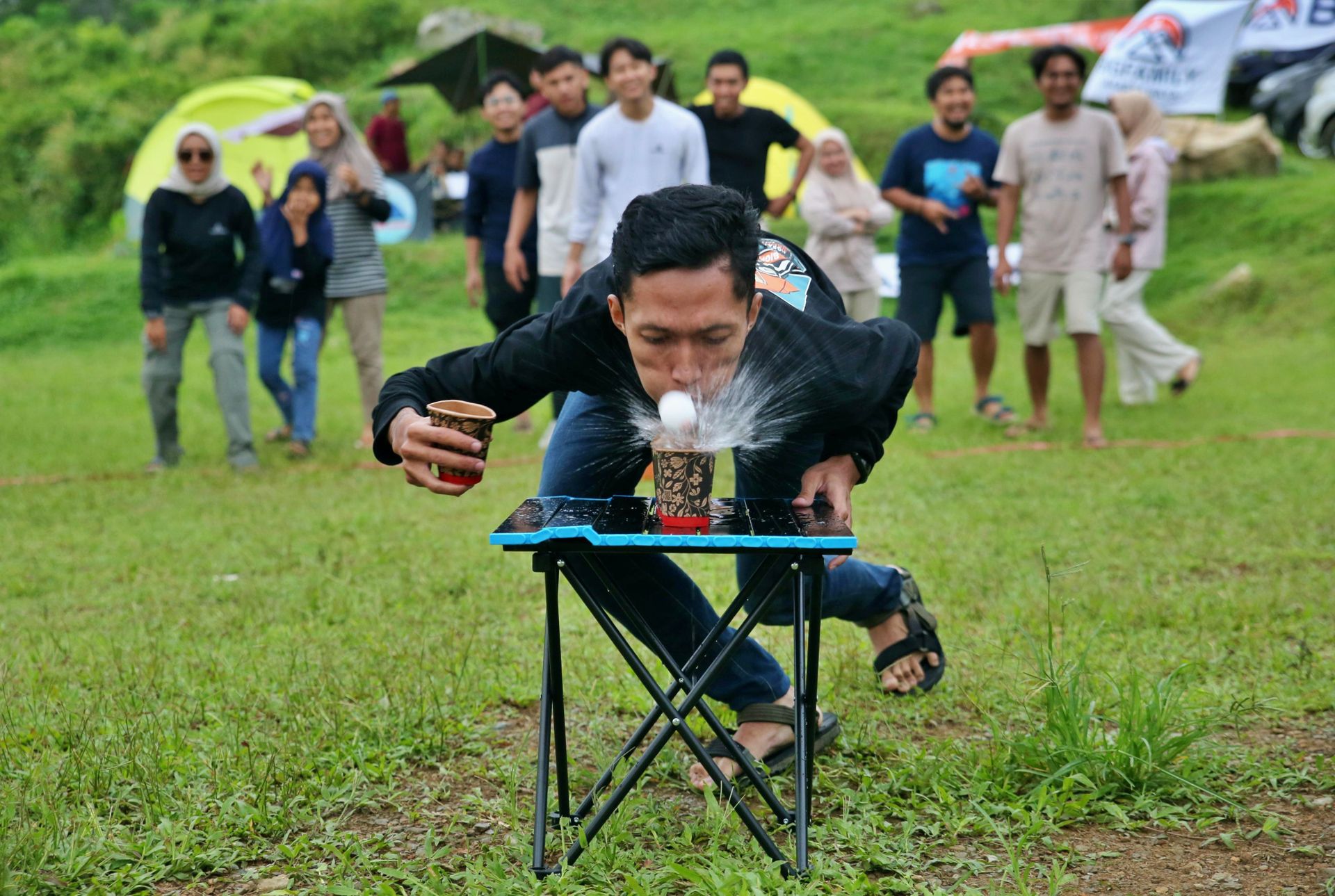 Group of friends enjoying an outdoor game competition, showcasing teamwork and playful fun.