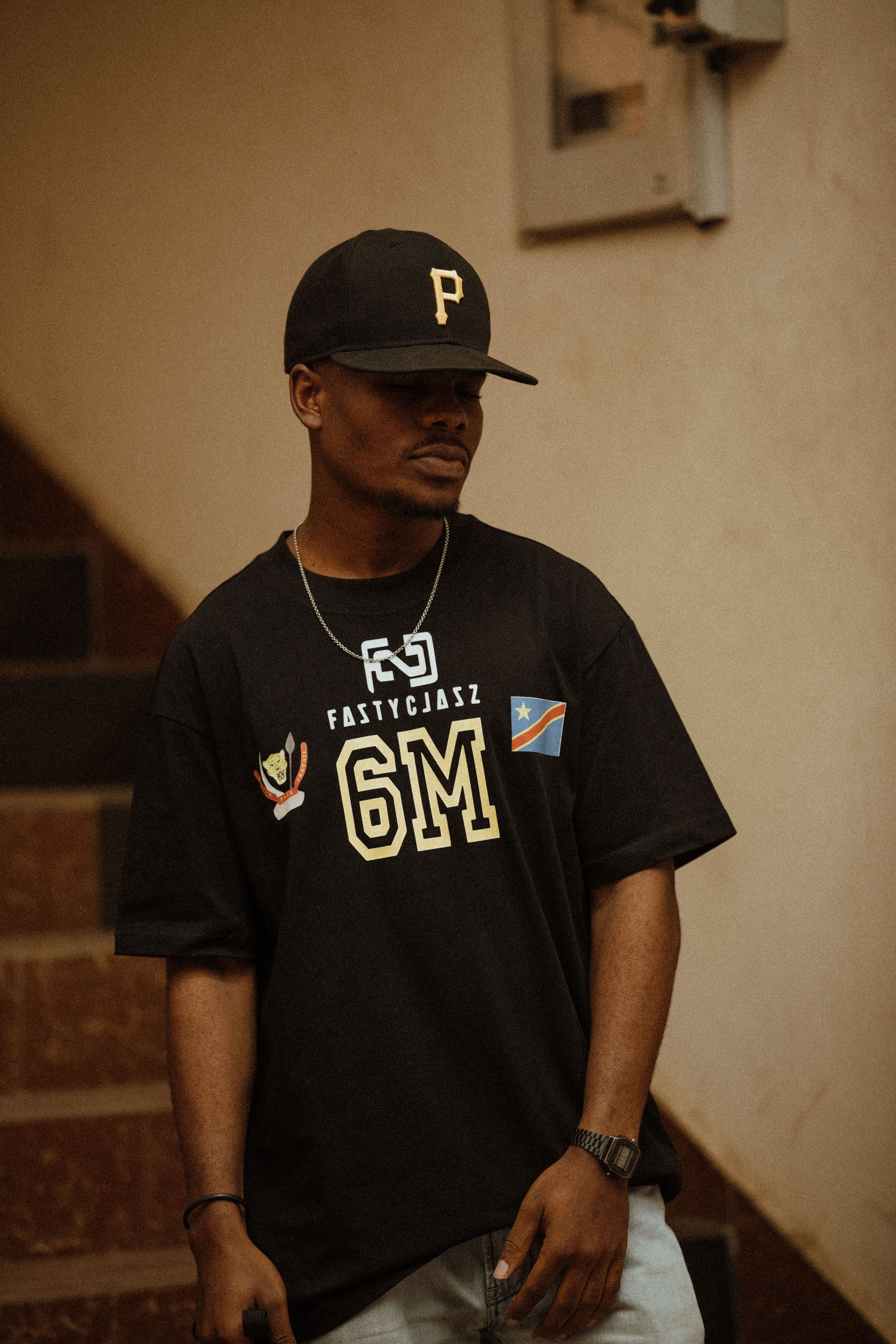 Casual fashion portrait of a young man standing indoors with urban style.