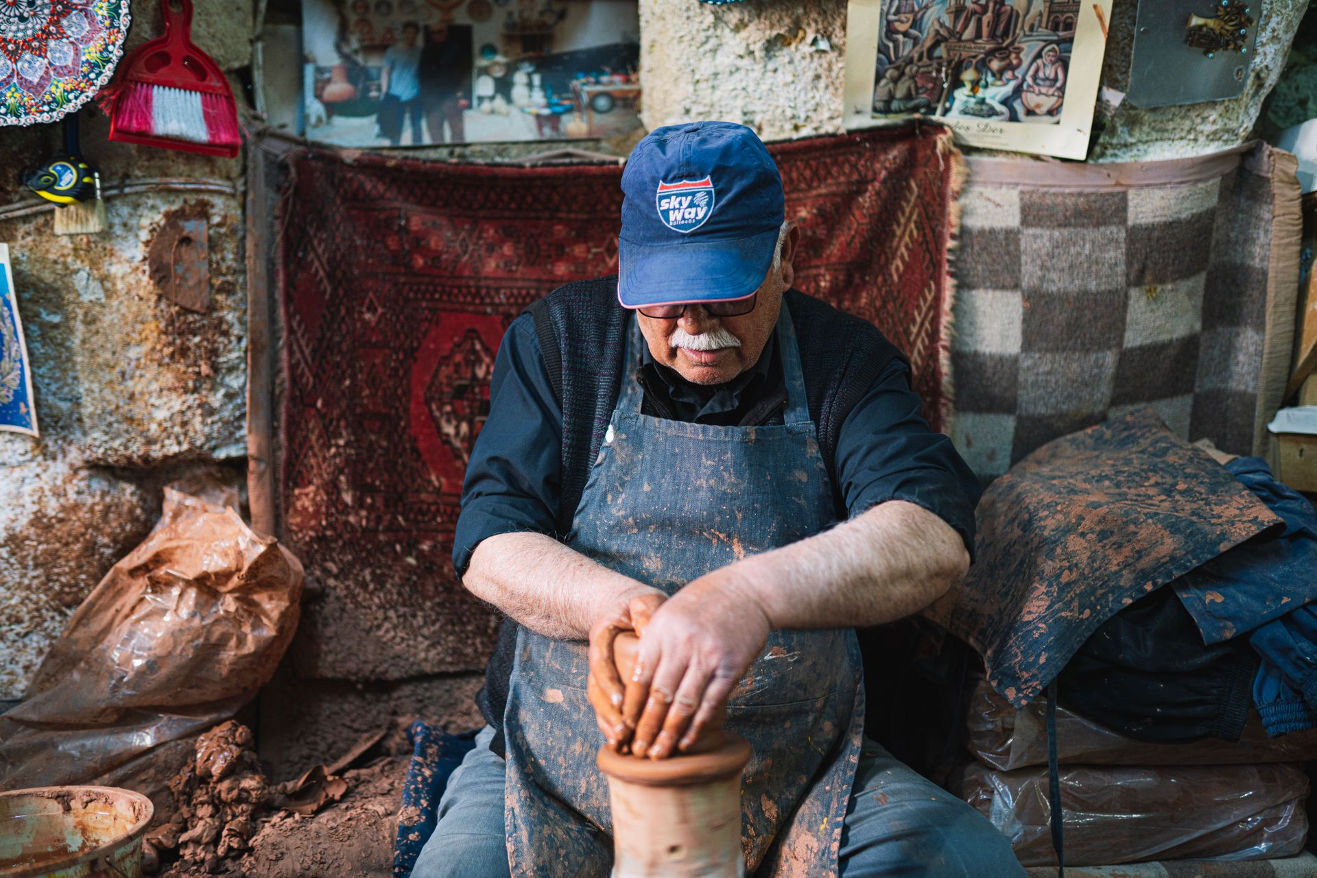 An artisan crafts pottery in a rustic workshop in Göreme, showcasing traditional techniques and Turkish craftsmanship.