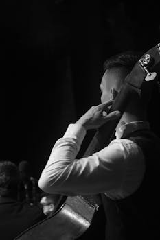 Elegant black and white photo capturing a bass player performing on stage, focusing on musical passion.