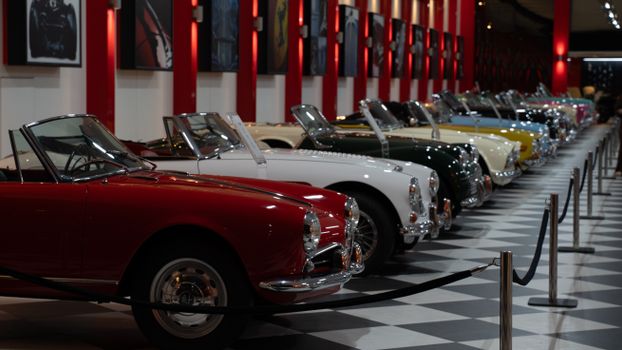 A row of vintage convertible cars showcased in an indoor museum in İzmir, Türkiye.
