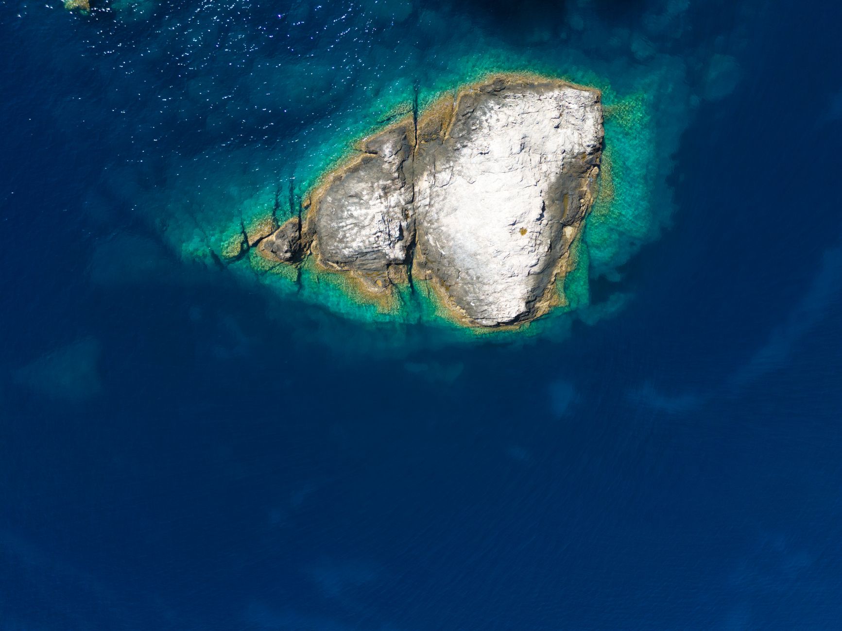 Aerial view of Paros island showing white villages, blue waters, and golden beaches