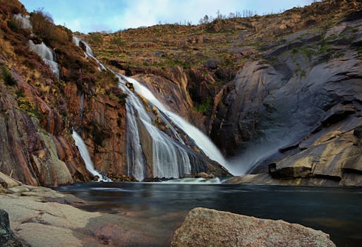 Beautiful waterfalls cascade over rocky cliffs in Carnota, Galicia, Spain.