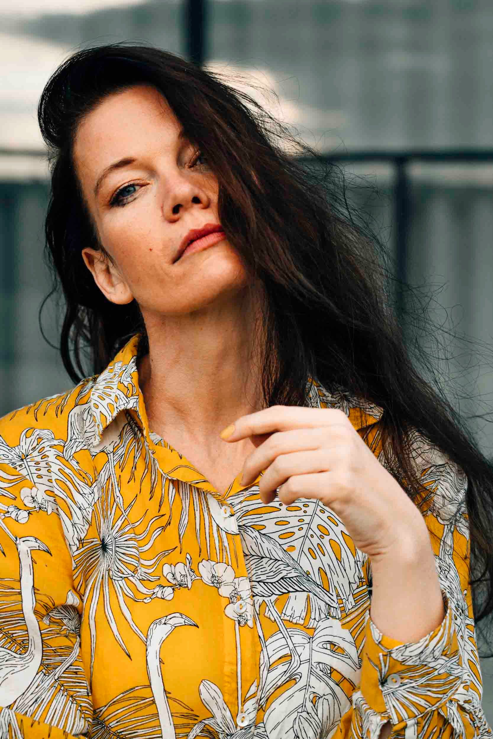 Portrait of a stylish woman wearing a floral yellow shirt in Berlin.