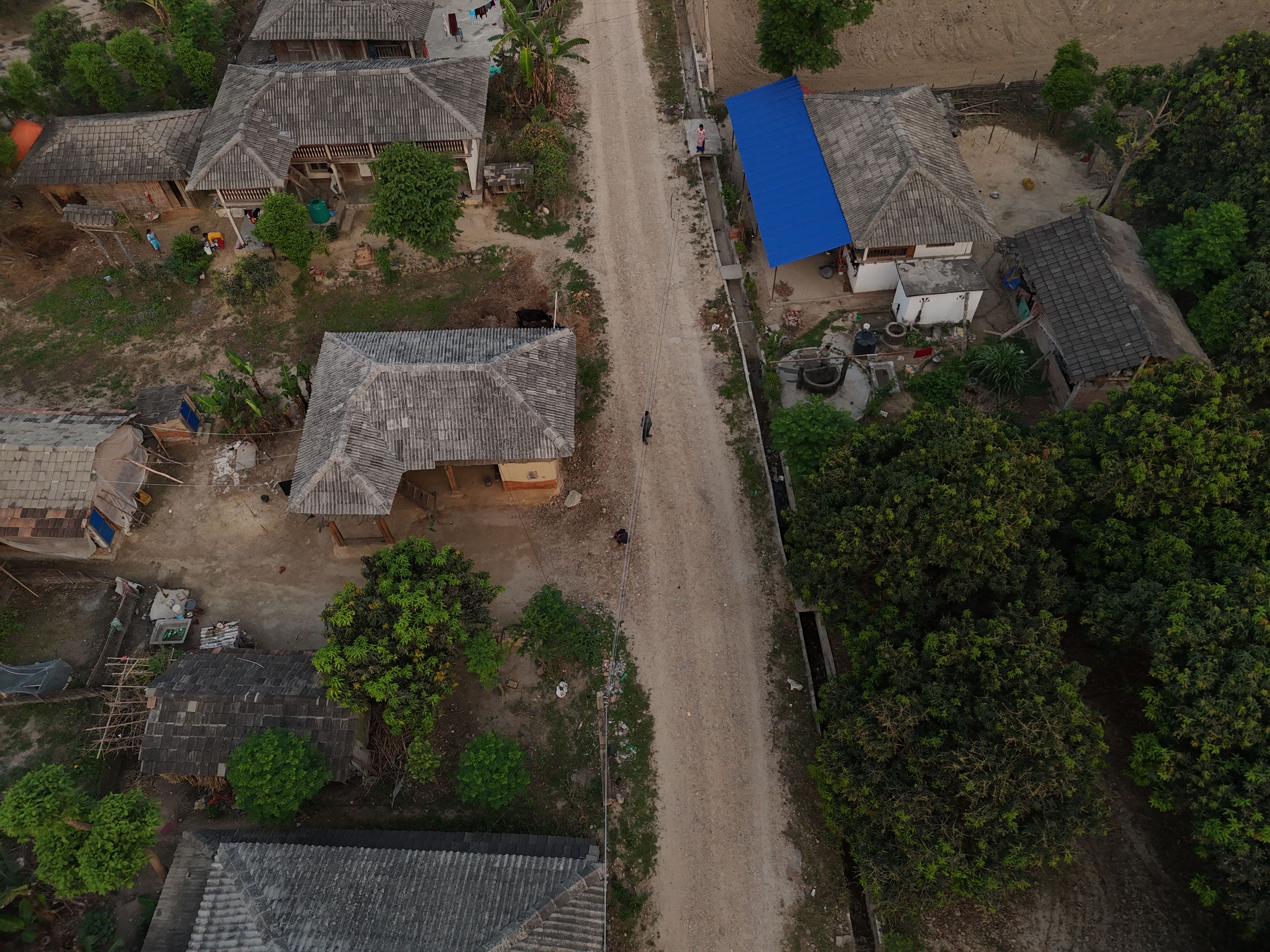 Incredible Everest Base Camp Helicopter Tour with Landing from Kathmandu Review 2026 - An aerial photo showing traditional houses and a dirt road in a rural Nepalese village.