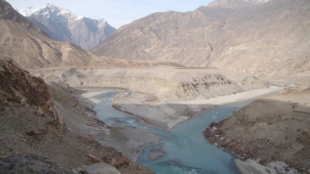 Breathtaking view of the Karakoram Range with a meandering river in Gilgit-Baltistan, Pakistan.