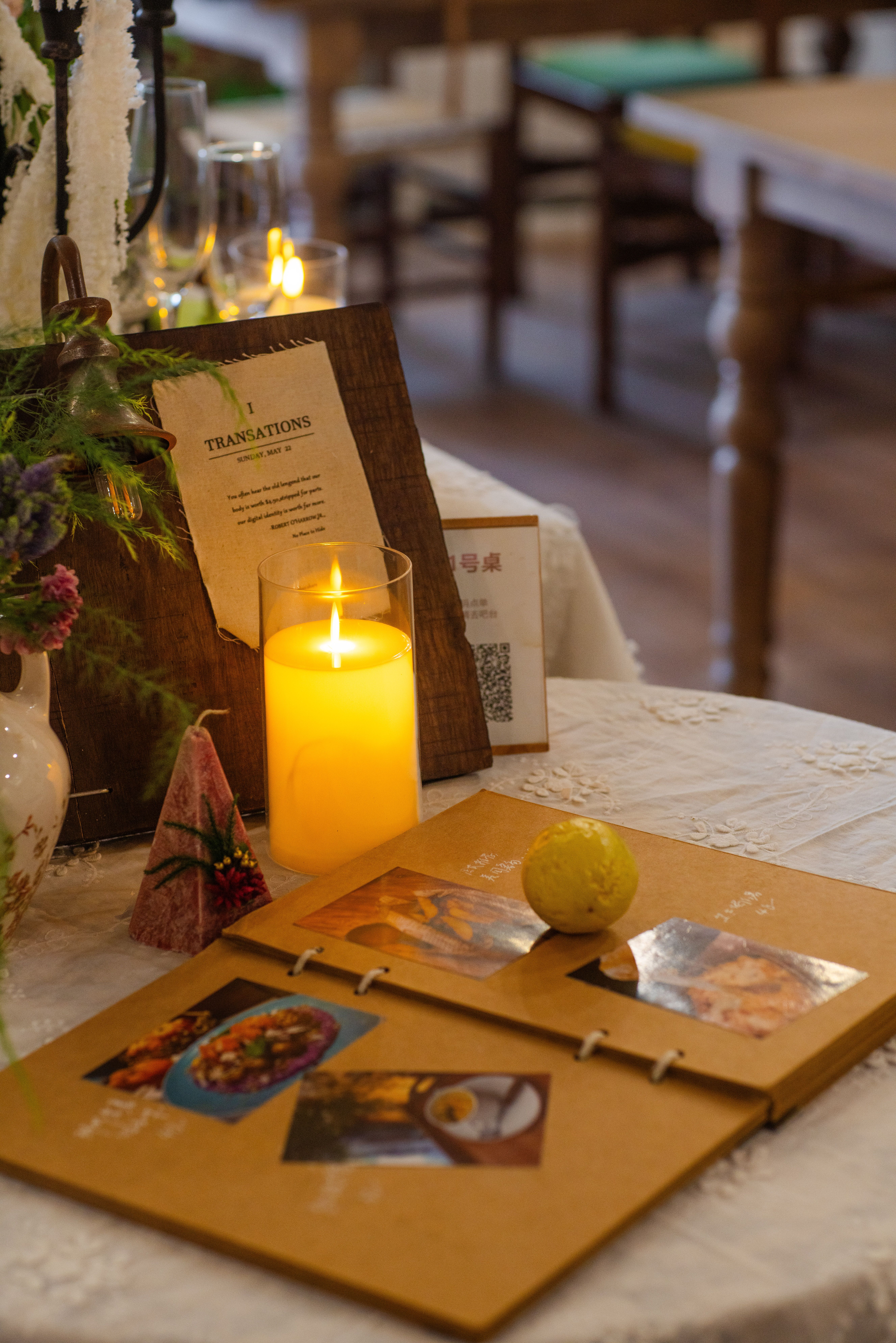 Inviting restaurant table with flickering candle and photo album, perfect ambiance for dining.