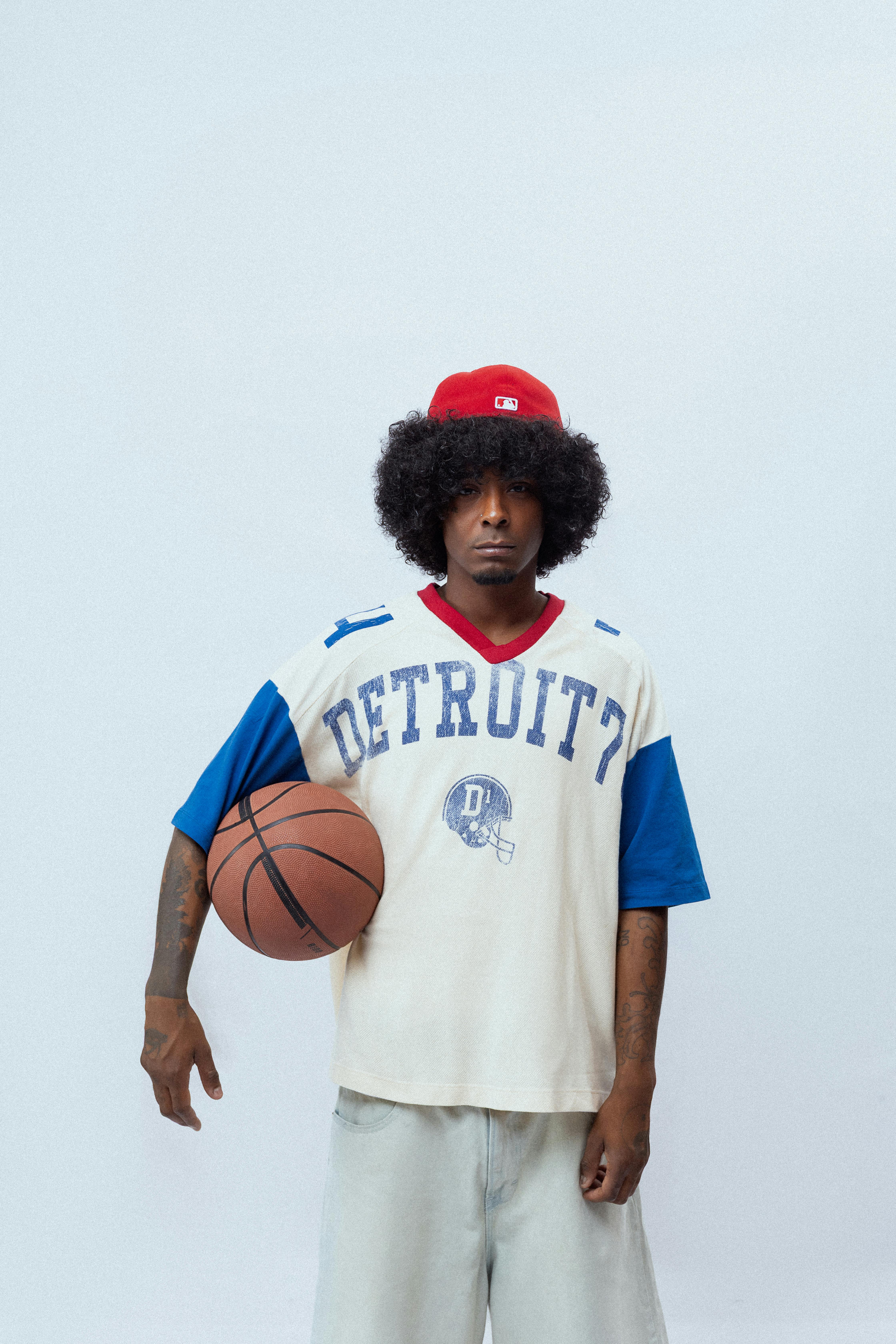 Jovem com bola de basquete mostrando confiança e espírito esportivo, inspirado pelo Detroit Pistons