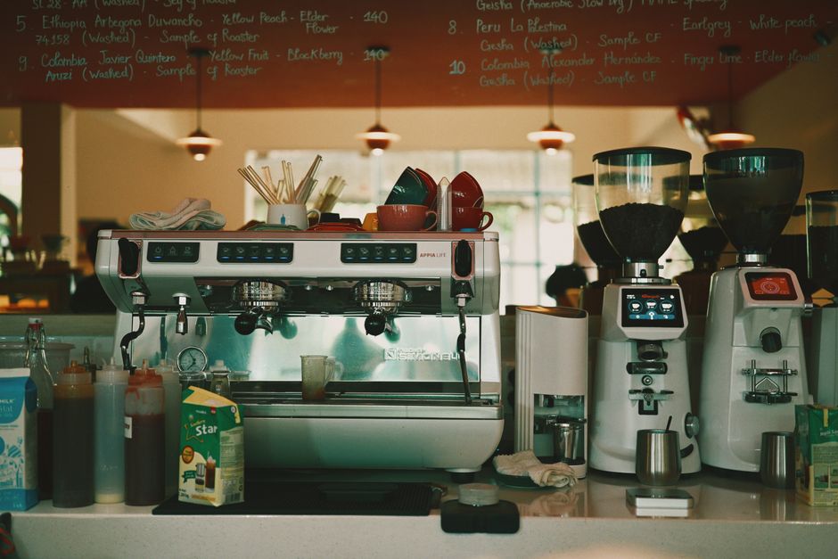 Sleek espresso machine with cups and grinders in a cozy cafe interior.