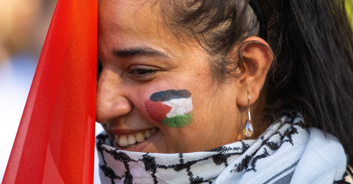 Smiling Woman Holding Palestinian Flag at Demonstration · Free Stock Photo