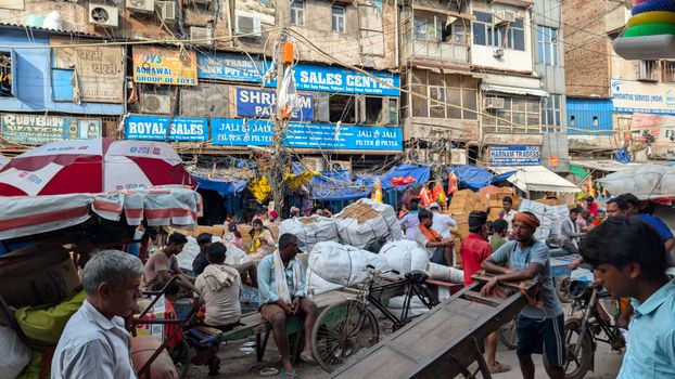 A vibrant and bustling street market in Old Delhi, India, with numerous vendors and shoppers.