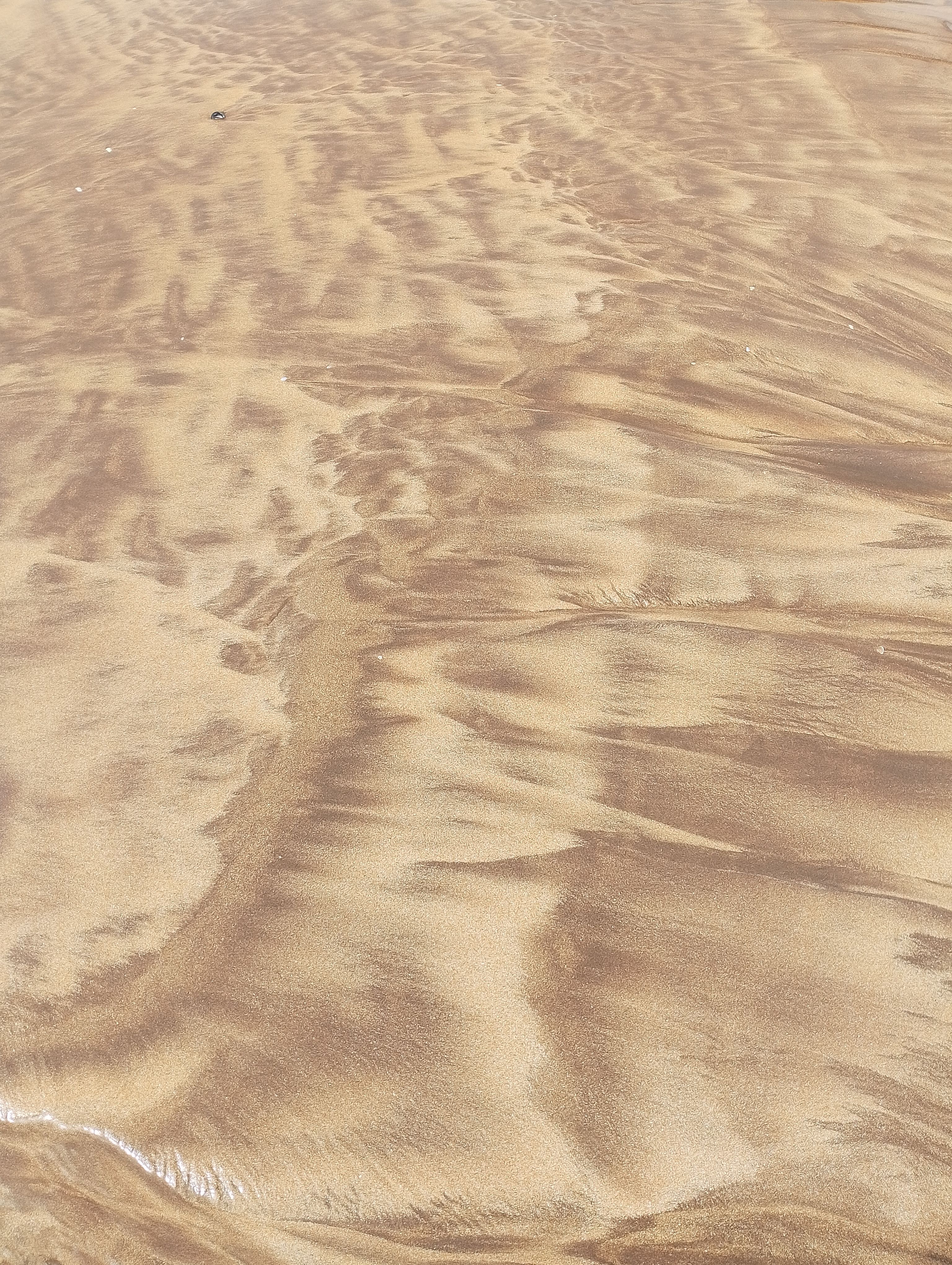 Captivating patterns in the sand at Casablanca beach, showcasing nature's artistry.