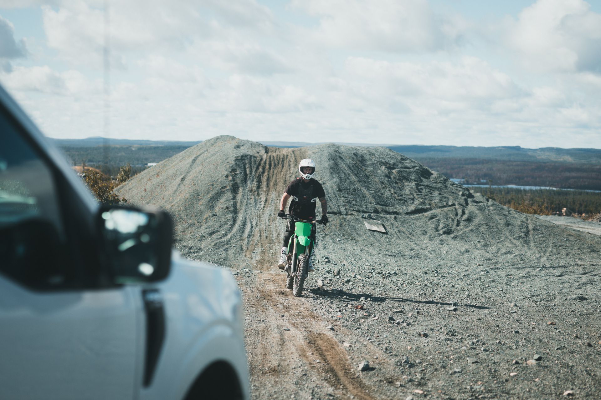A dirt biker navigates rocky terrain, capturing a thrilling outdoor adventure in daylight.