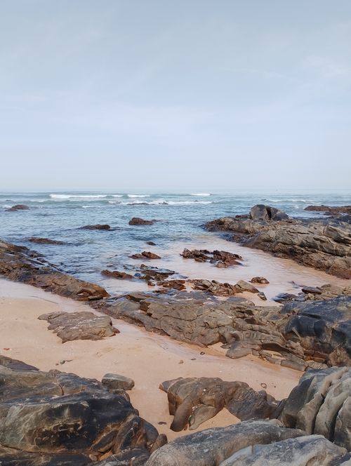 Free Tranquil rocky shoreline with gentle waves at a beach in Casablanca, showcasing natural beauty and serenity. Stock Photo