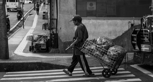 Free A street vendor pushes a cart across the street in Baguio, Philippines, showcasing daily market life. Stock Photo