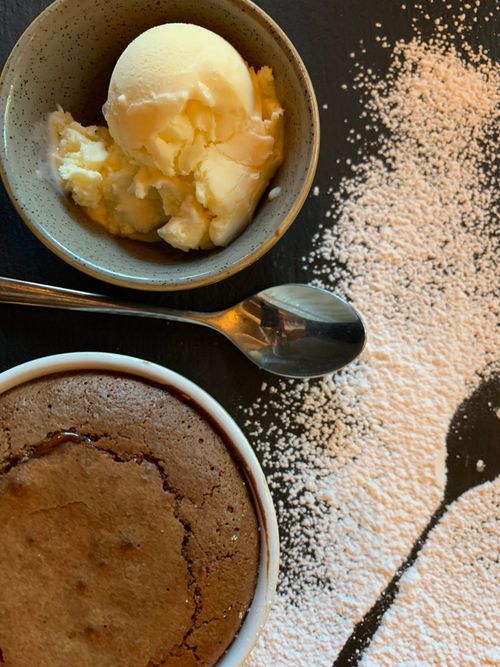 Free Chocolate fondant with vanilla ice cream and powdered sugar elegantly arranged, perfect for dessert inspiration. Stock Photo