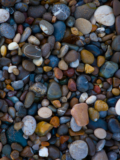 Free A colorful collection of various sized pebbles on a beach, offering a natural textured background. Stock Photo