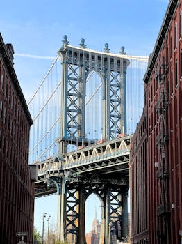 Stunning view of Manhattan Bridge framed by red brick buildings in New York City.