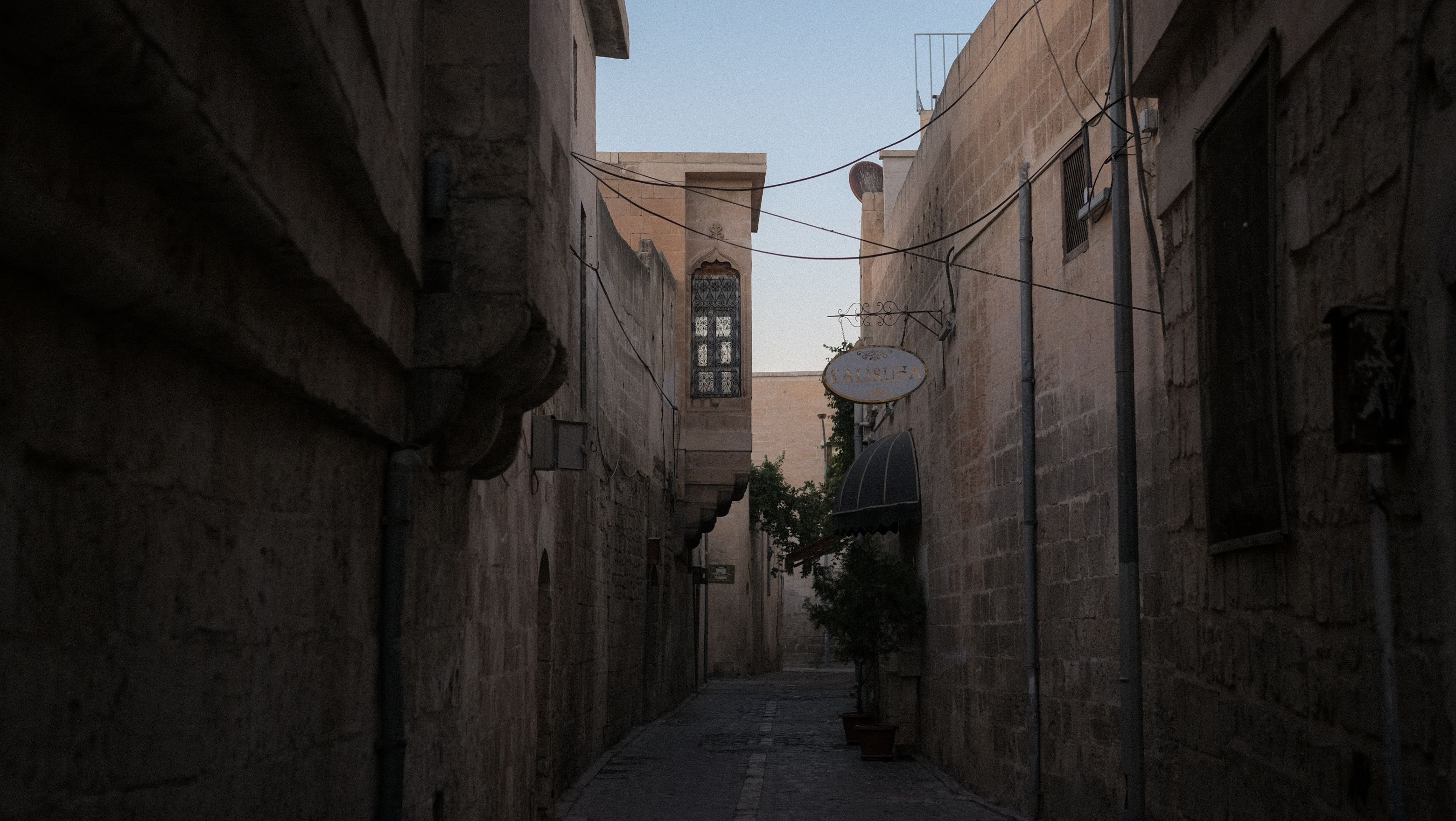 Narrow lane inside the Venetian walls of old Nicosia with sandstone houses and a mosque minaret behind
