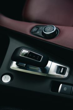 Close-up of a luxury car gearshift in a modern vehicle interior with leather finish.