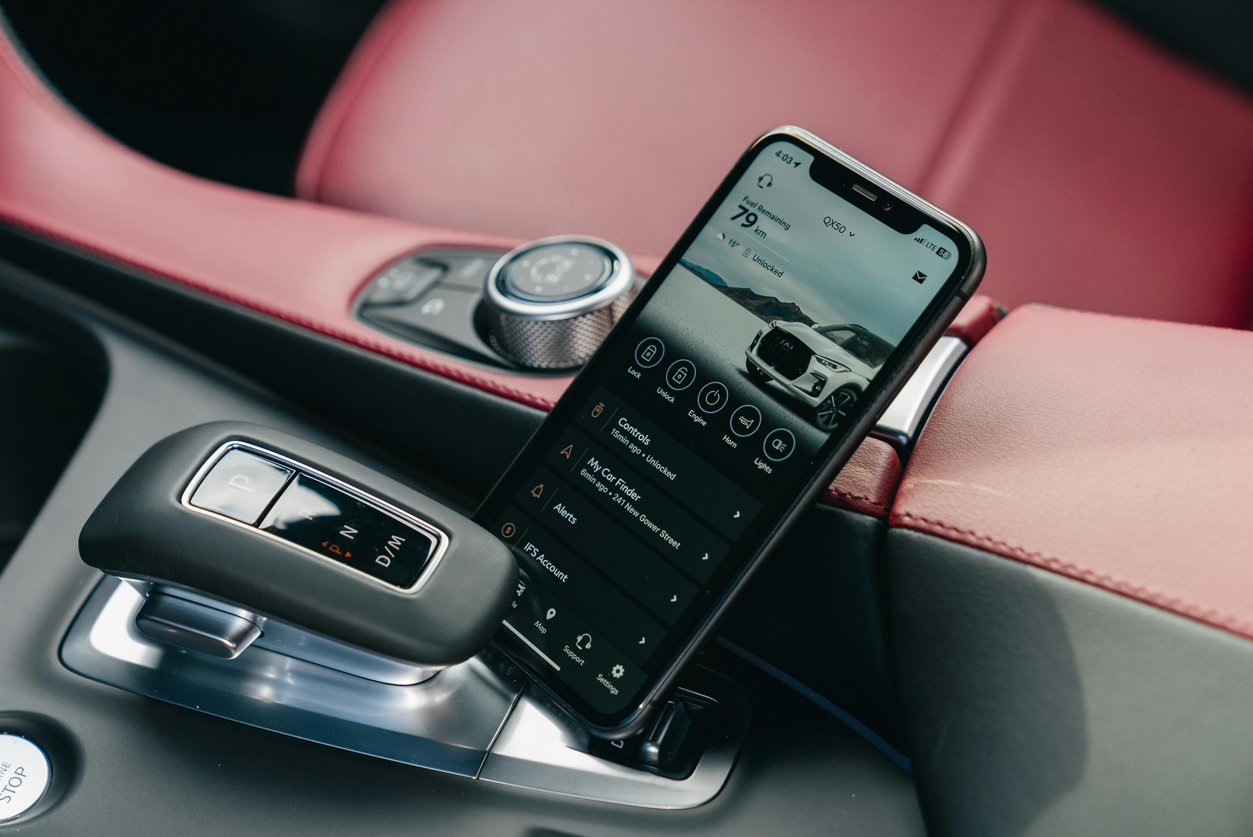Free Close-up of smartphone with car control app in a luxury car's interior, showcasing modern technology. Stock Photo