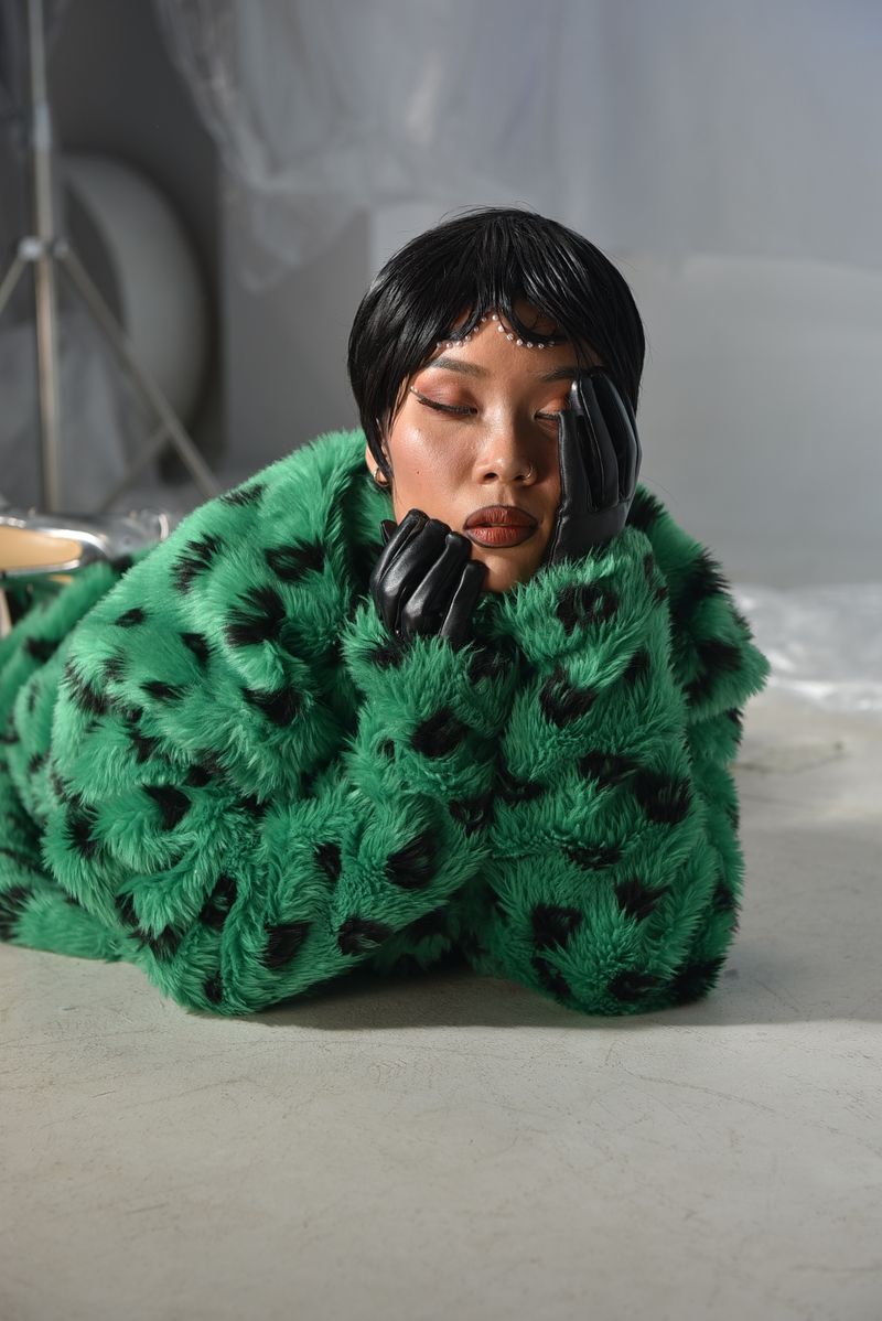 Woman in green fur coat in an elegant studio portrait