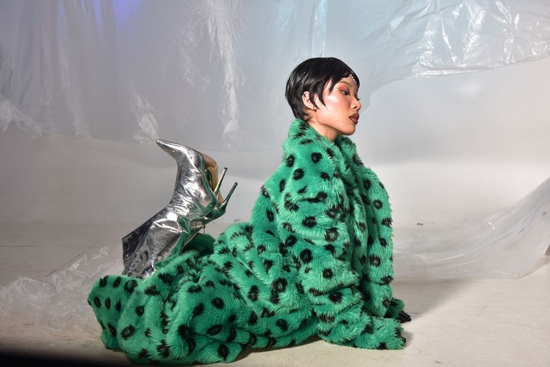 Woman in green fur coat with silver heels
