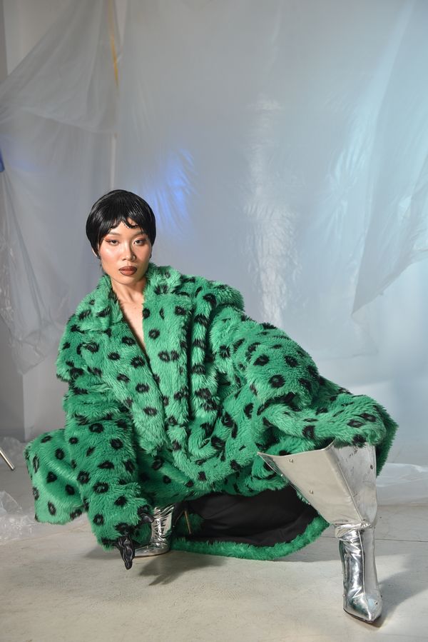 Fashionable woman in green faux fur coat with silver boots