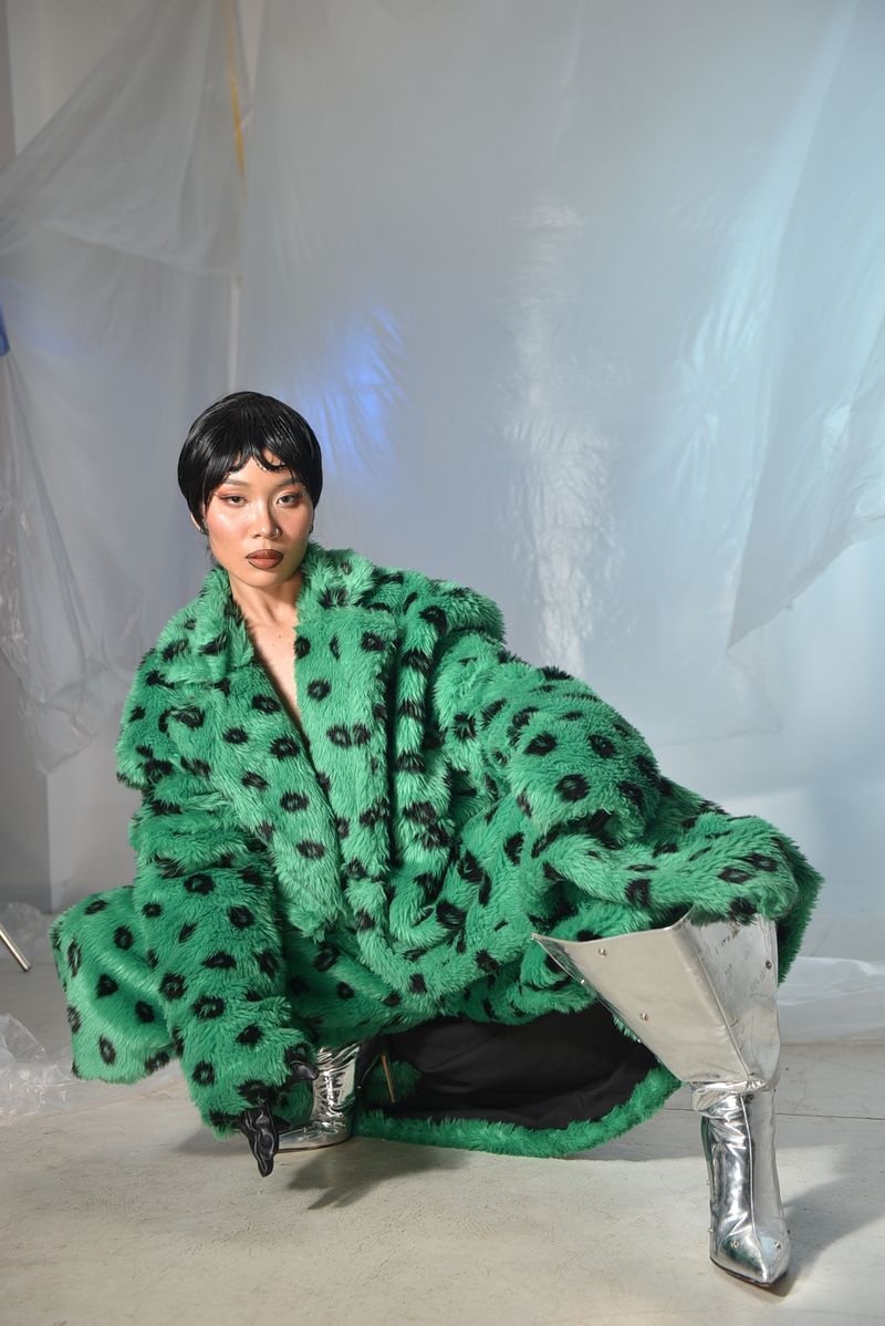 Woman in green faux fur coat with silver boots