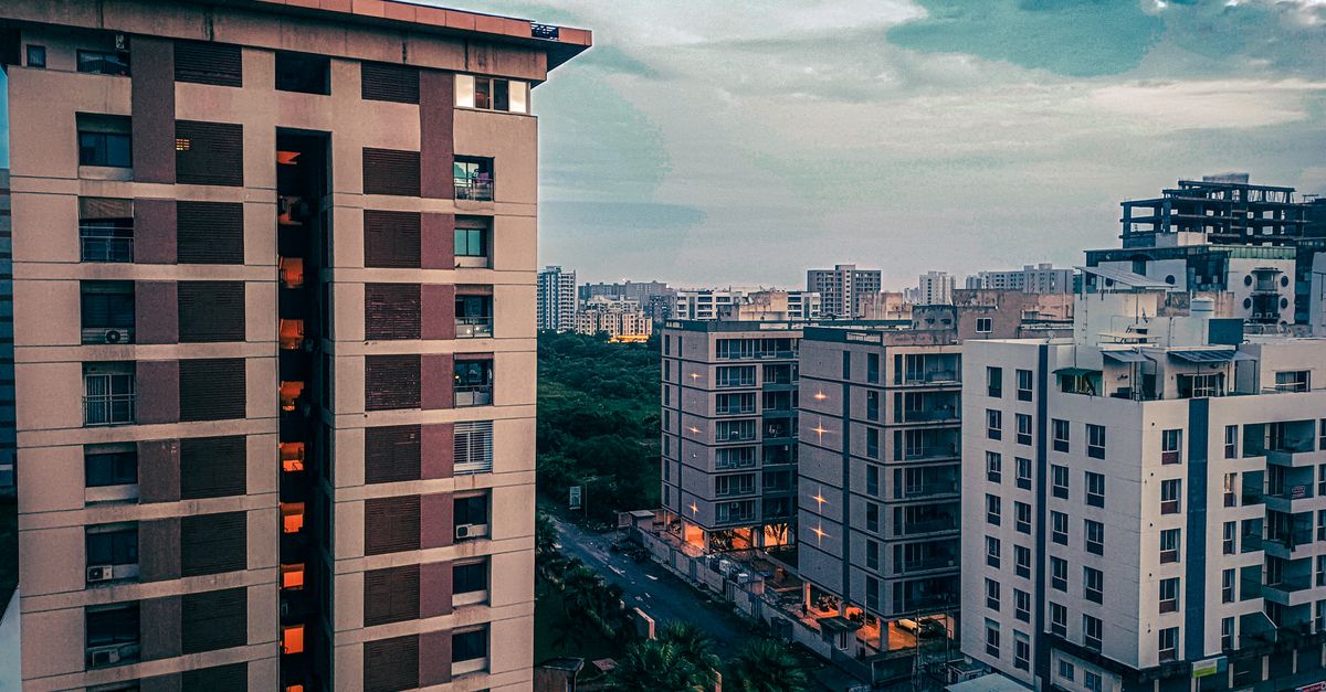 View of modern apartment buildings against a colorful twilight sky in an urban setting.