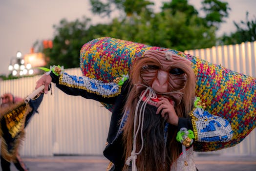 Masked performer in vibrant attire during an outdoor festival.