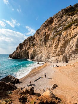 Breathtaking view of a rocky coastline, turquoise sea, and a secluded pebble beach.