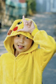 Young child wearing a Pikachu costume making a fun gesture outside in Talgar, Kazakhstan.