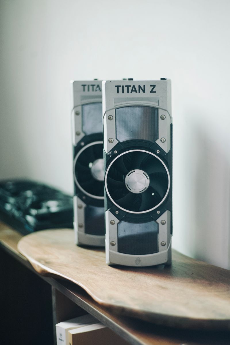 Two NVIDIA Titan Z graphics cards positioned on a wooden desk