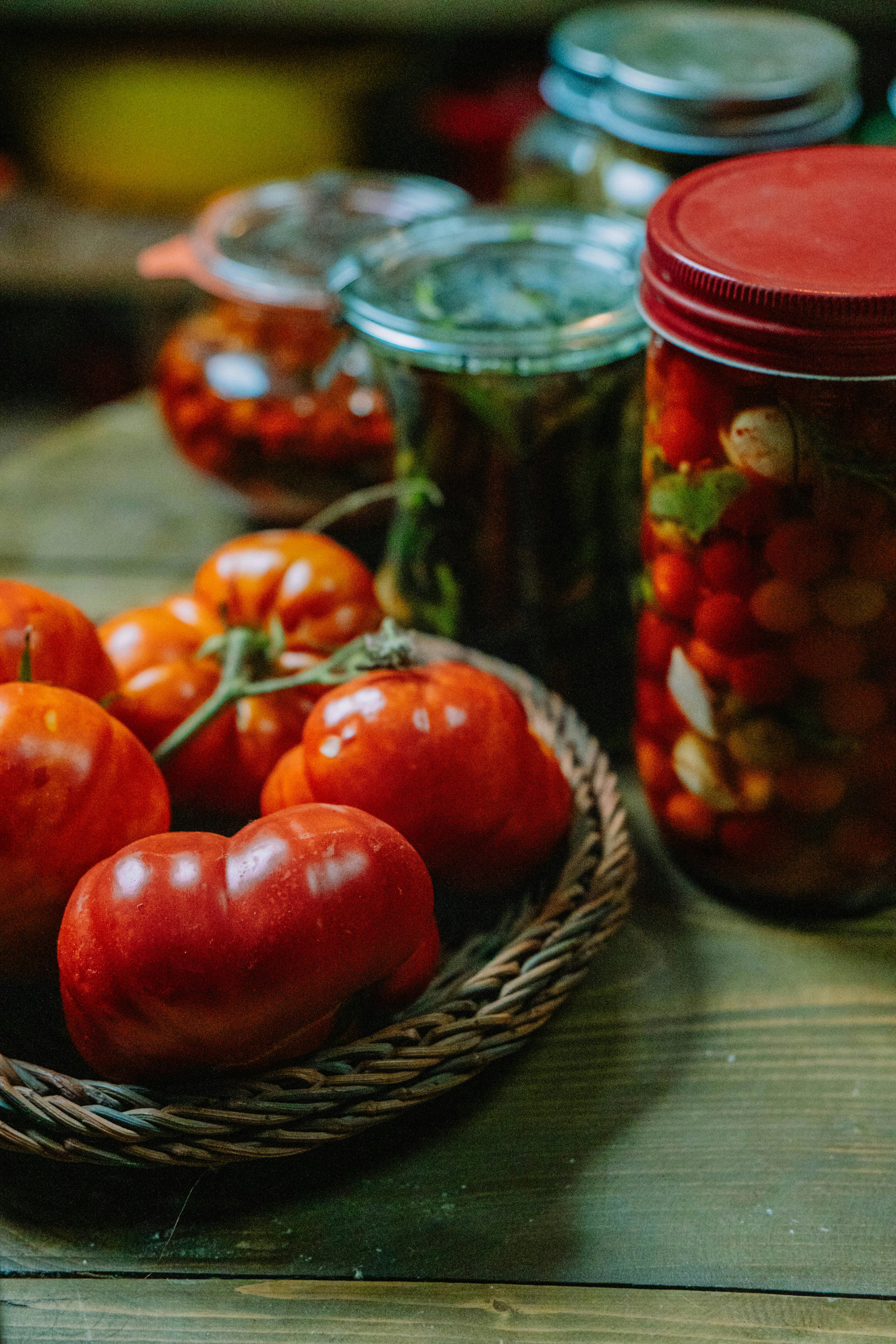 Rustic kitchen setting with fresh tomatoes and canned vegetables, highlighting natural produce.