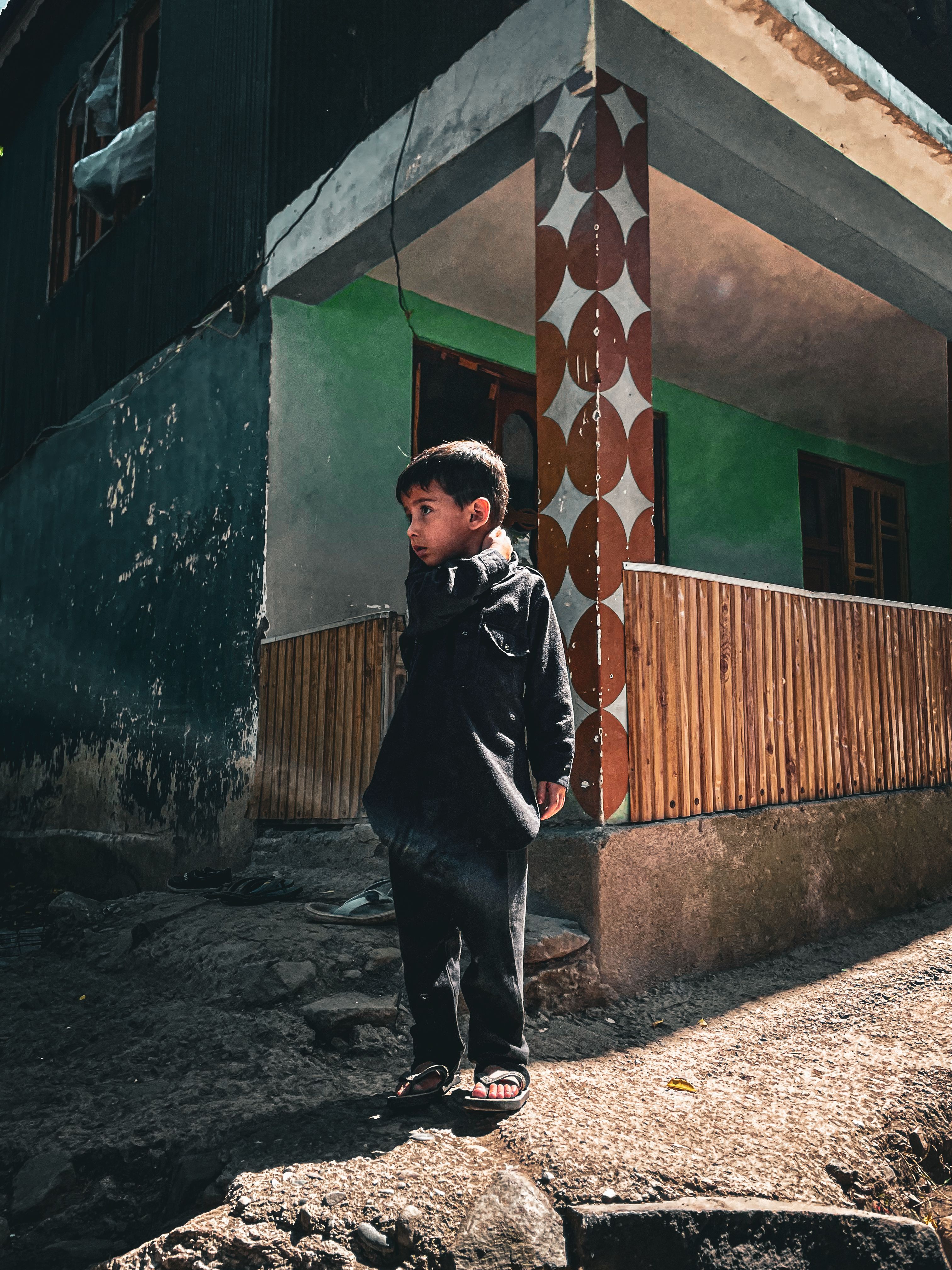 Child Standing in Front of Rustic House · Free Stock Photo
