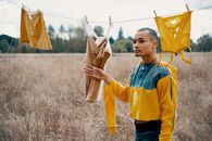 时尚年轻人拿着衣服在户外排成一排，展现现代时尚