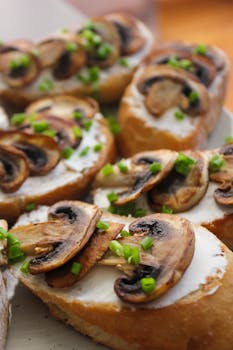 Close-up of mushroom and cream cheese bruschetta garnished with green onions.
