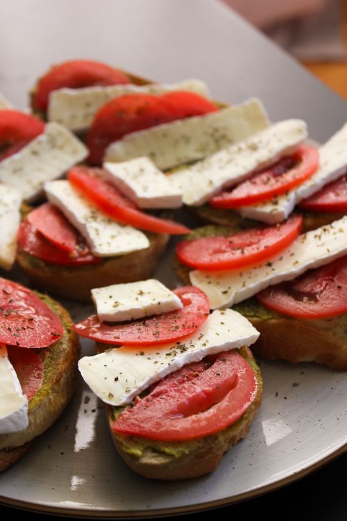 Free Close-up of appetizer with tomato and brie on toast garnished with herbs. Stock Photo