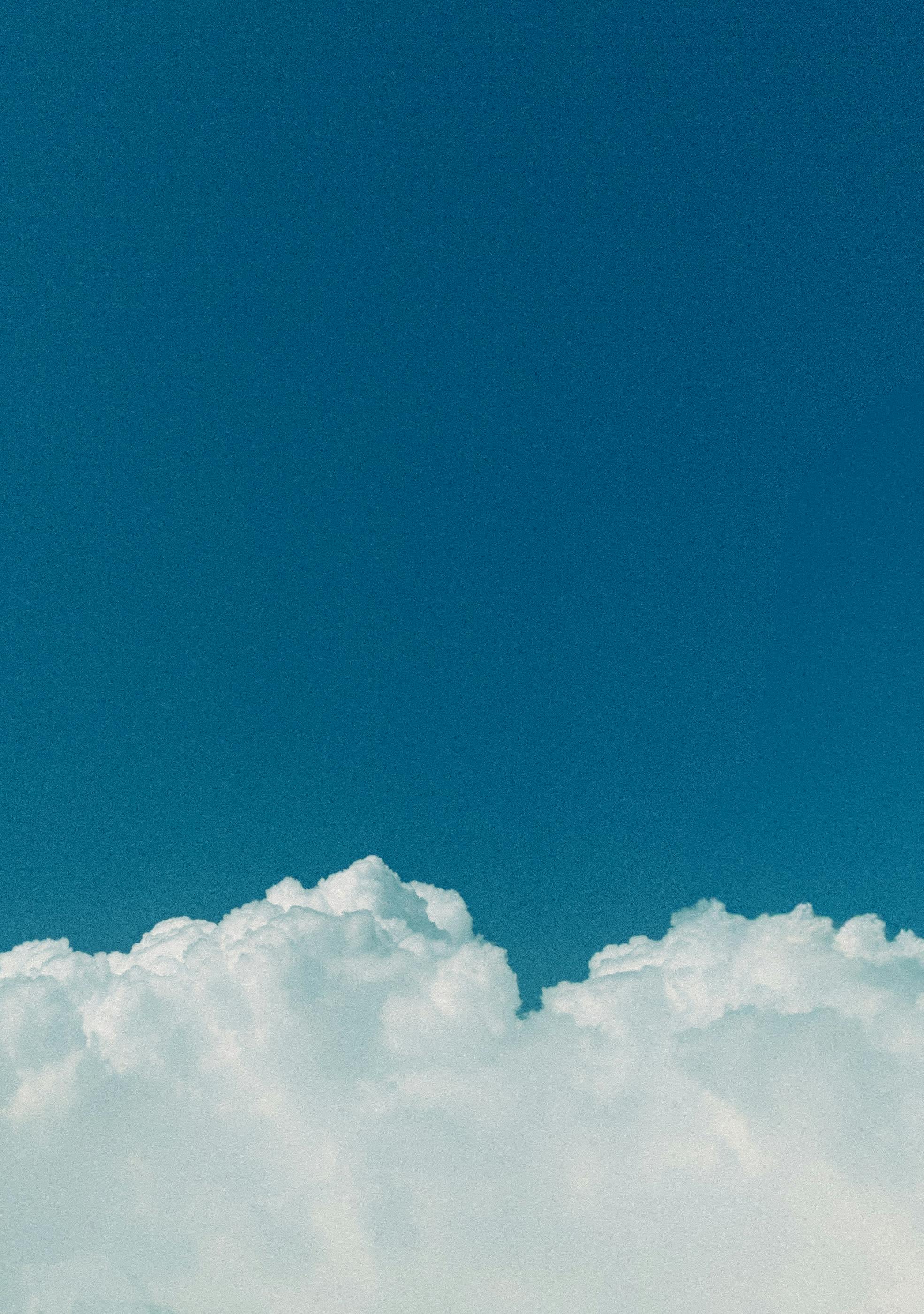 Gratis Cautivadora vista de un cielo azul claro adornado con esponjosas nubes blancas, que evoca una sensación de tranquilidad y libertad. Foto de stock
