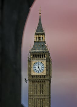Stunning view of Elizabeth Tower in London at dusk with a vibrant pink sky.