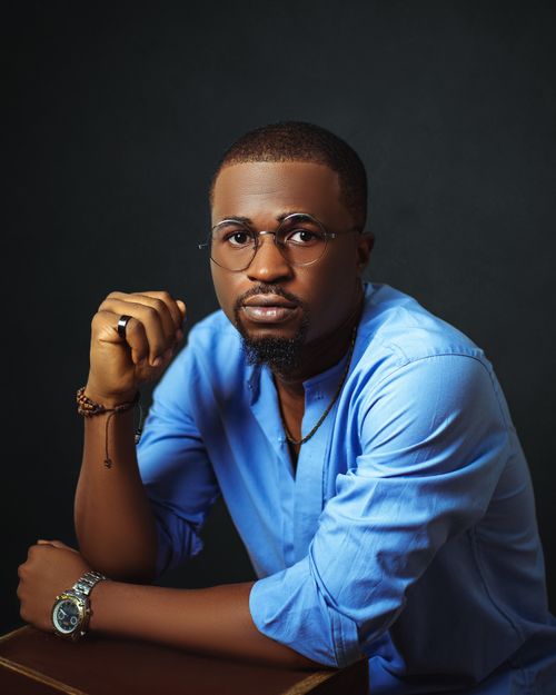 Free Portrait of a confident man with glasses in a blue shirt, looking thoughtful. Stock Photo