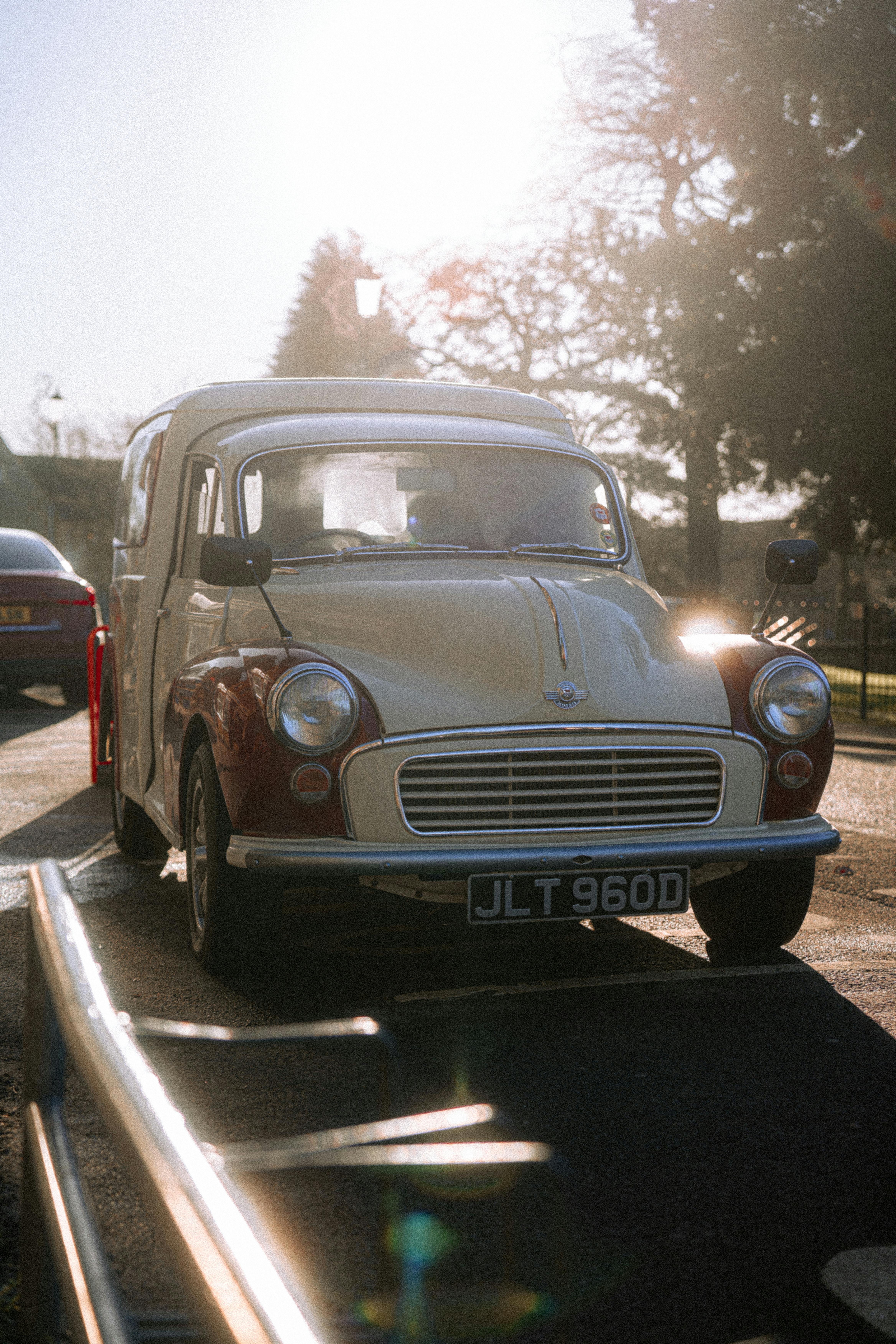 Classic car with license plate JLT 960D under bright sun on UK street.