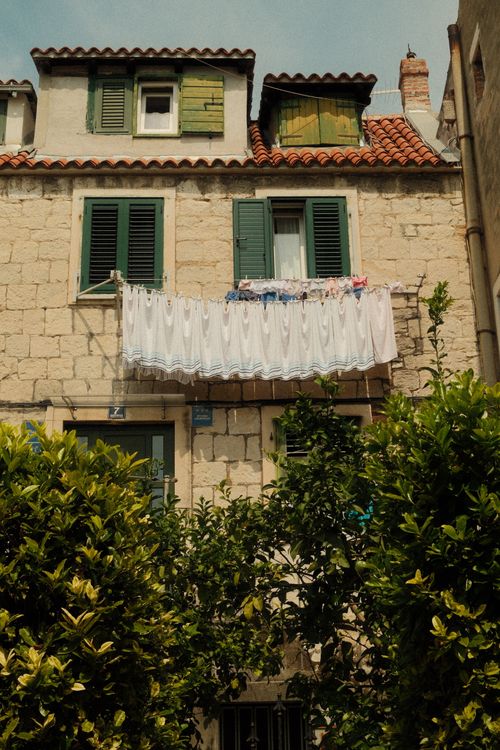 Free A quaint stone house facade with green shutters in Split, Croatia, showcasing classic Mediterranean architecture. Stock Photo