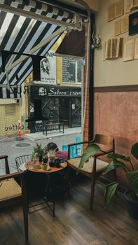 Charming cafe with wooden decor, plants, and a street view. Perfect for relaxation.