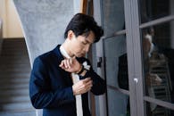 Elegant Man Adjusting Watch in Stylish Indoor Setting