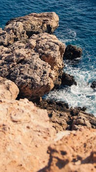 Dramatic rocky coastline with waves crashing against the shore. Perfect for outdoor and travel themes.